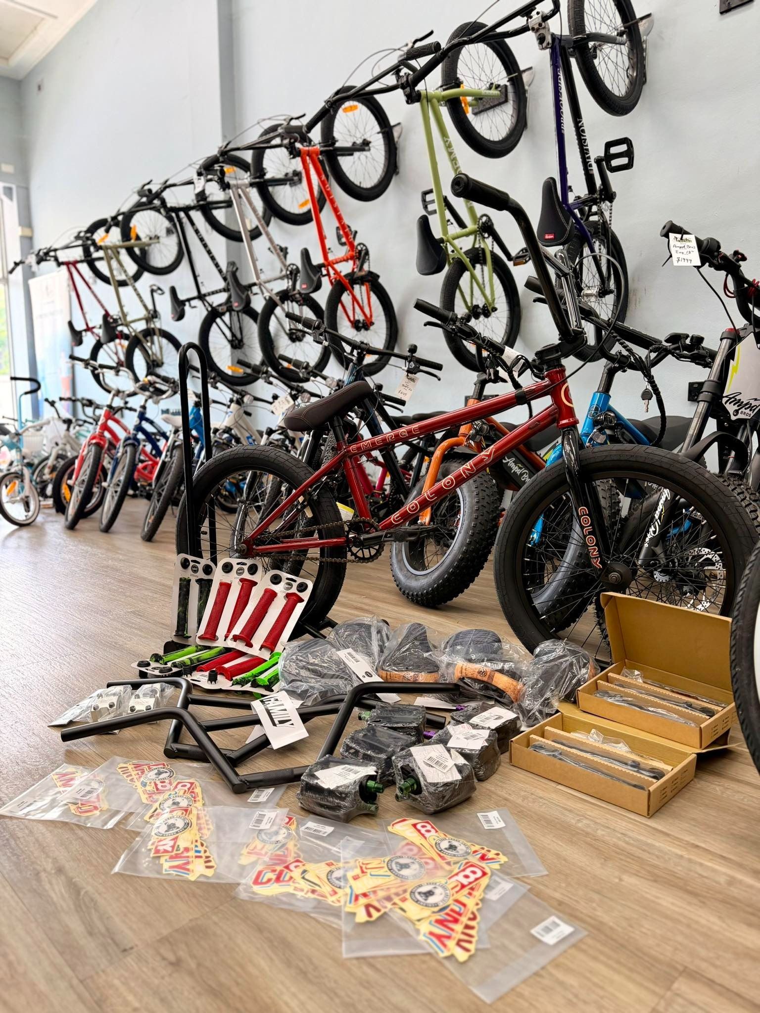 Bikes on display in a shop, with parts laid out in front.  Red, green, black and yellow bikes.  Wooden floor — Grafton City Cycles in Grafton, NSW