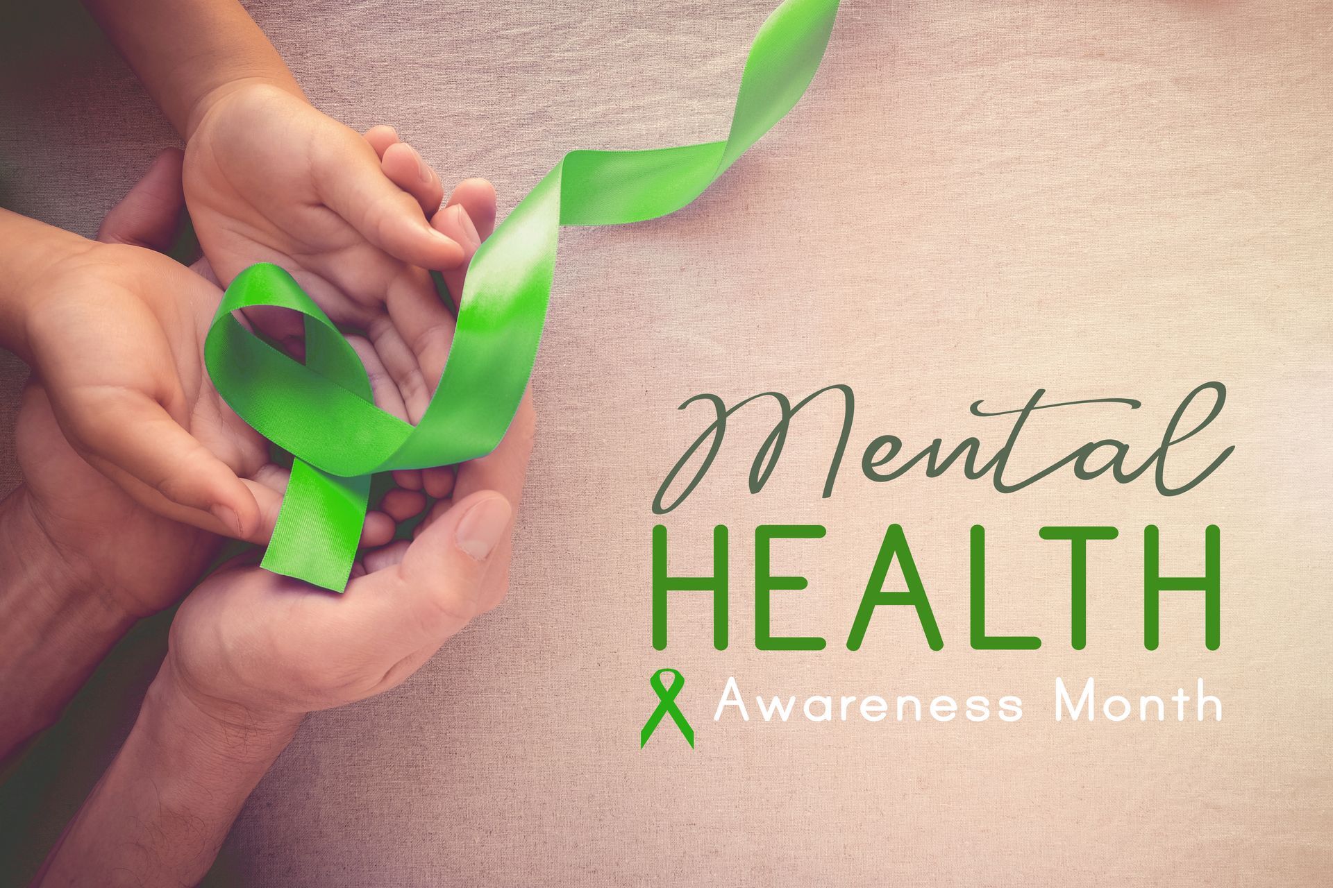 Hands holding a green ribbon beside “Mental Health Awareness Month” text.