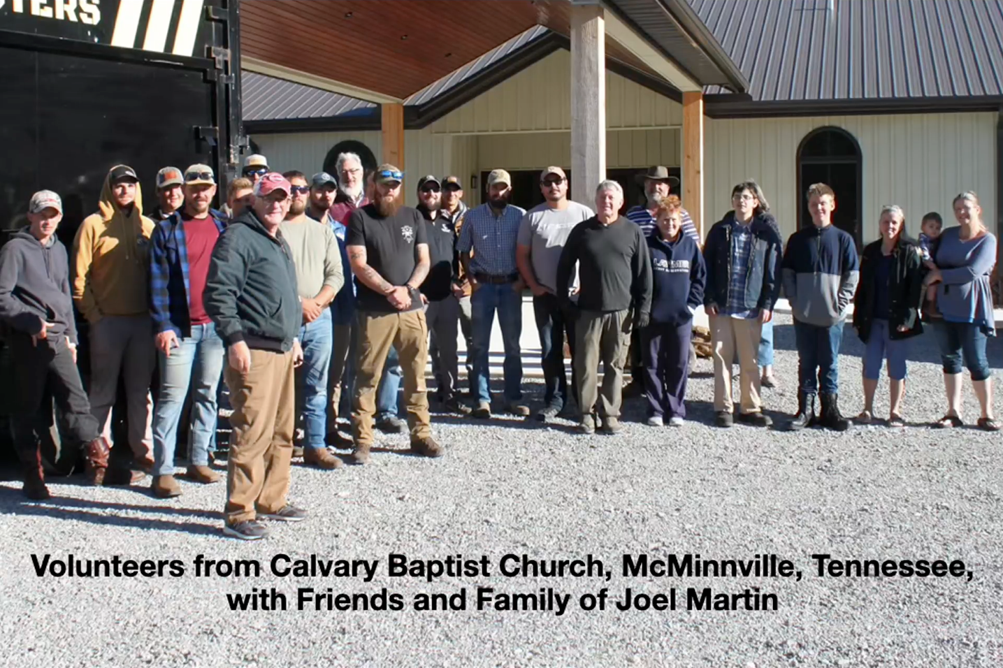Group of volunteers and family posing outside a building in McMinnville, Tennessee.