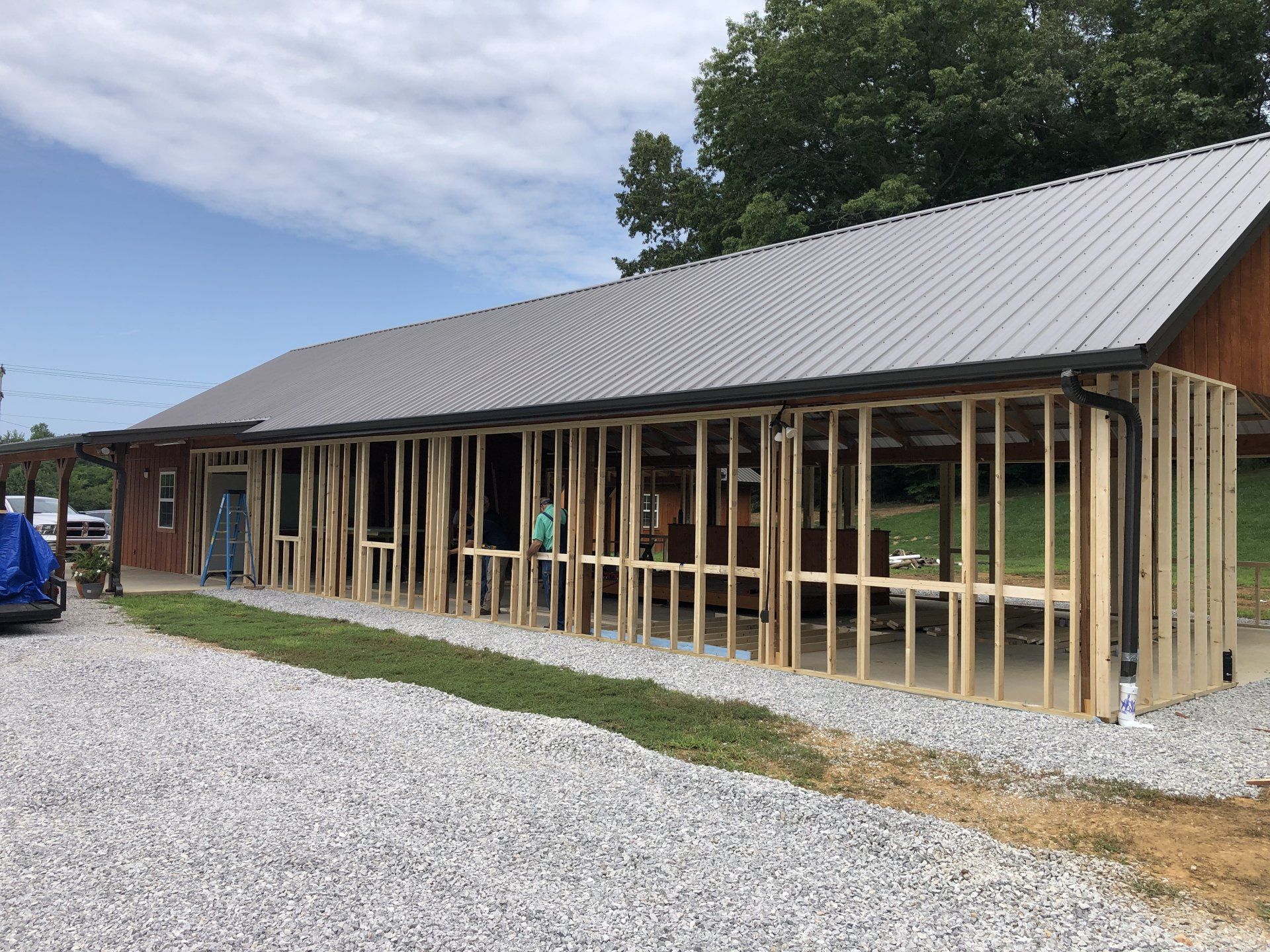 Building under construction with exposed wooden framework and metal roof.
