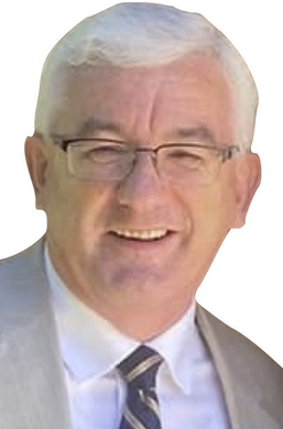 Man in glasses and suit smiles.