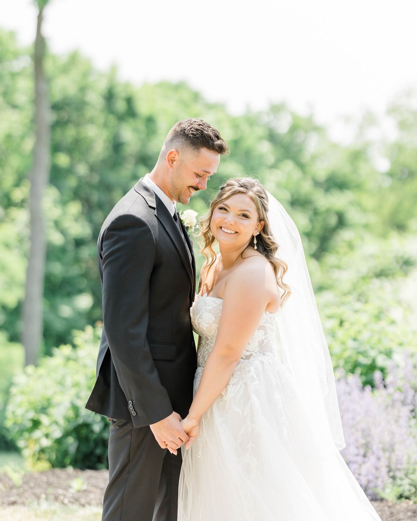 A bride and groom are posing for a picture on their wedding day.