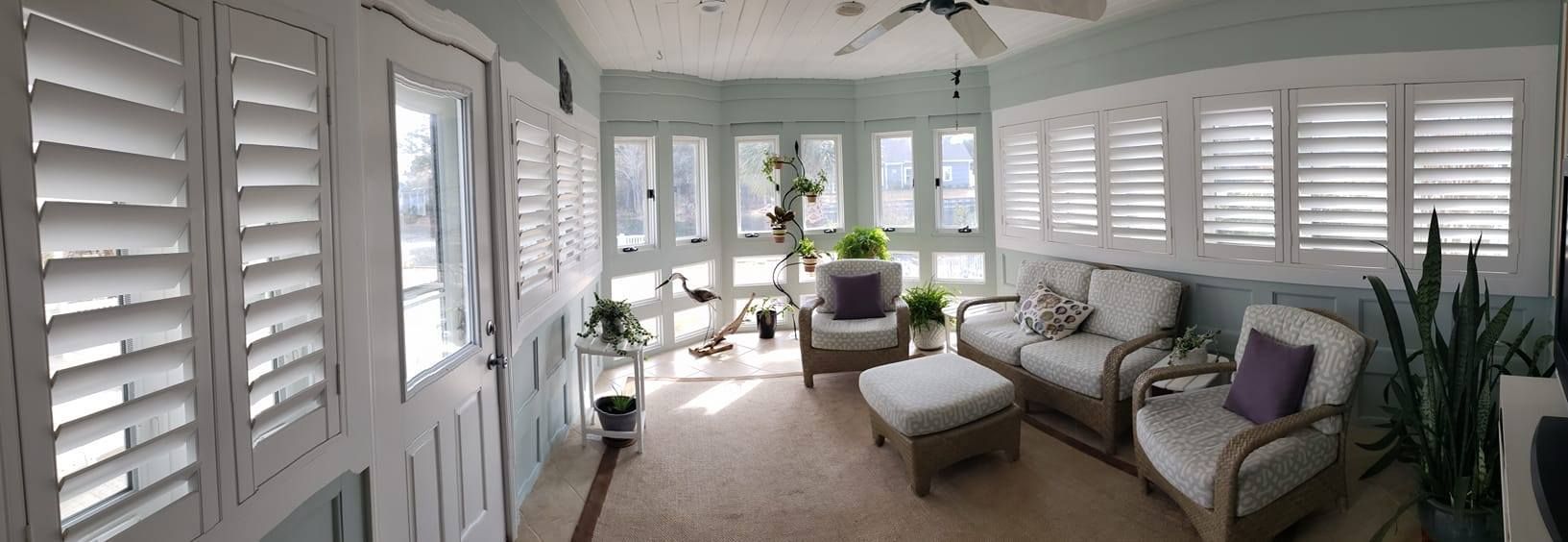 A living room with a lot of furniture and shutters on the windows.