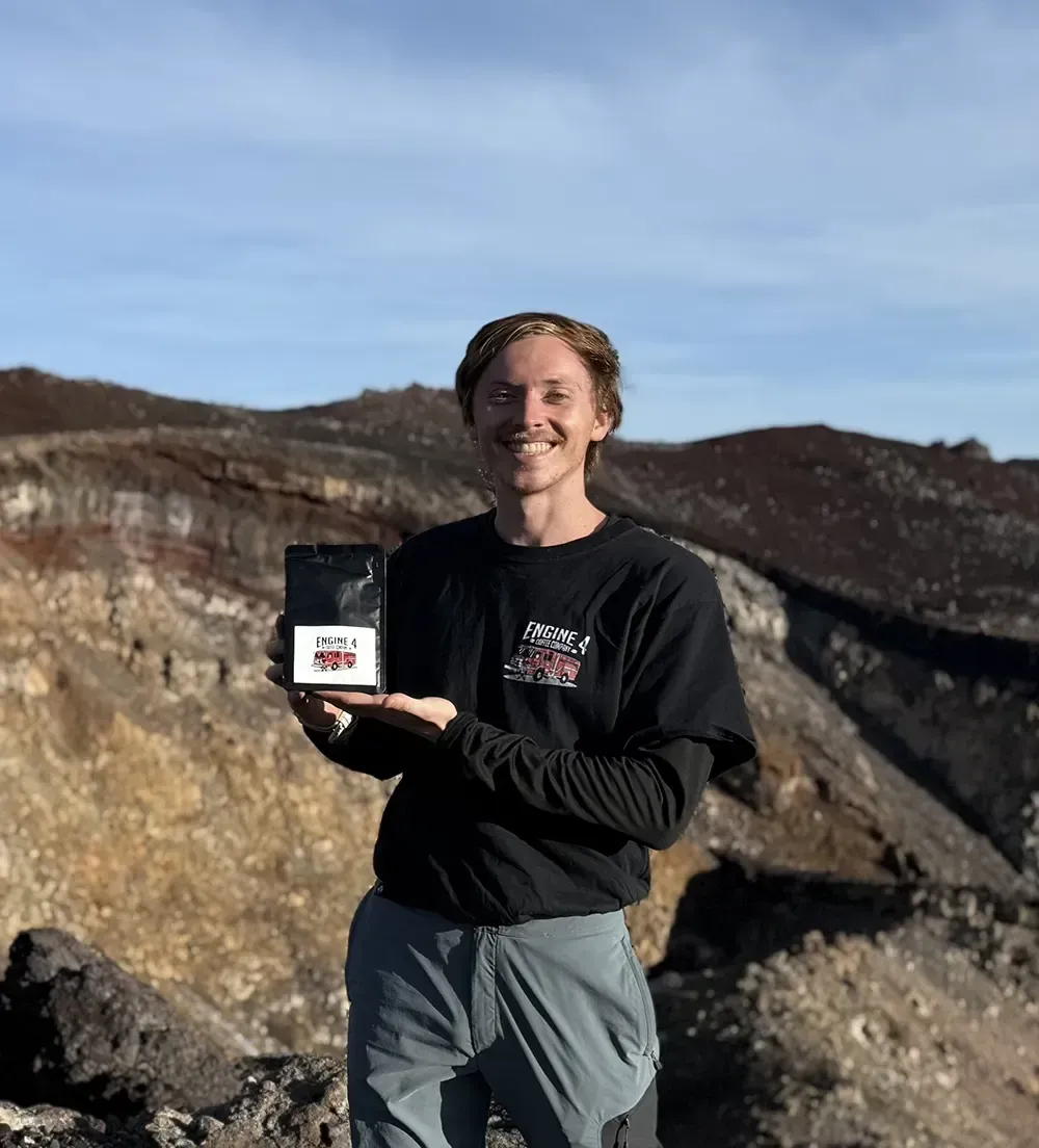 Justin holding Engine 4 Coffee Company Coffee Bag at Mt. Fuji.