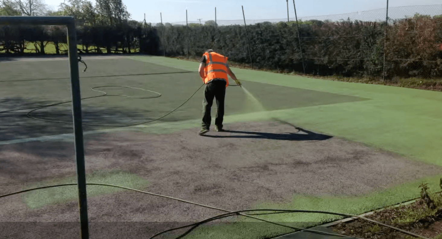 Worker repairing worn court surface before final coating during a court installation service in Chandler, AZ
