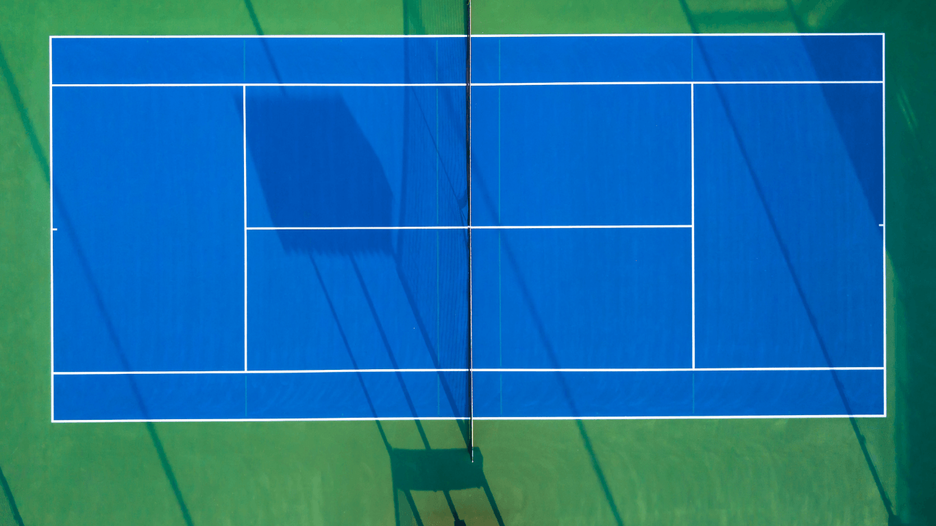 Overhead view of a freshly lined blue tennis court with clear boundaries and net shadow during a court installation service in Chandler, AZ