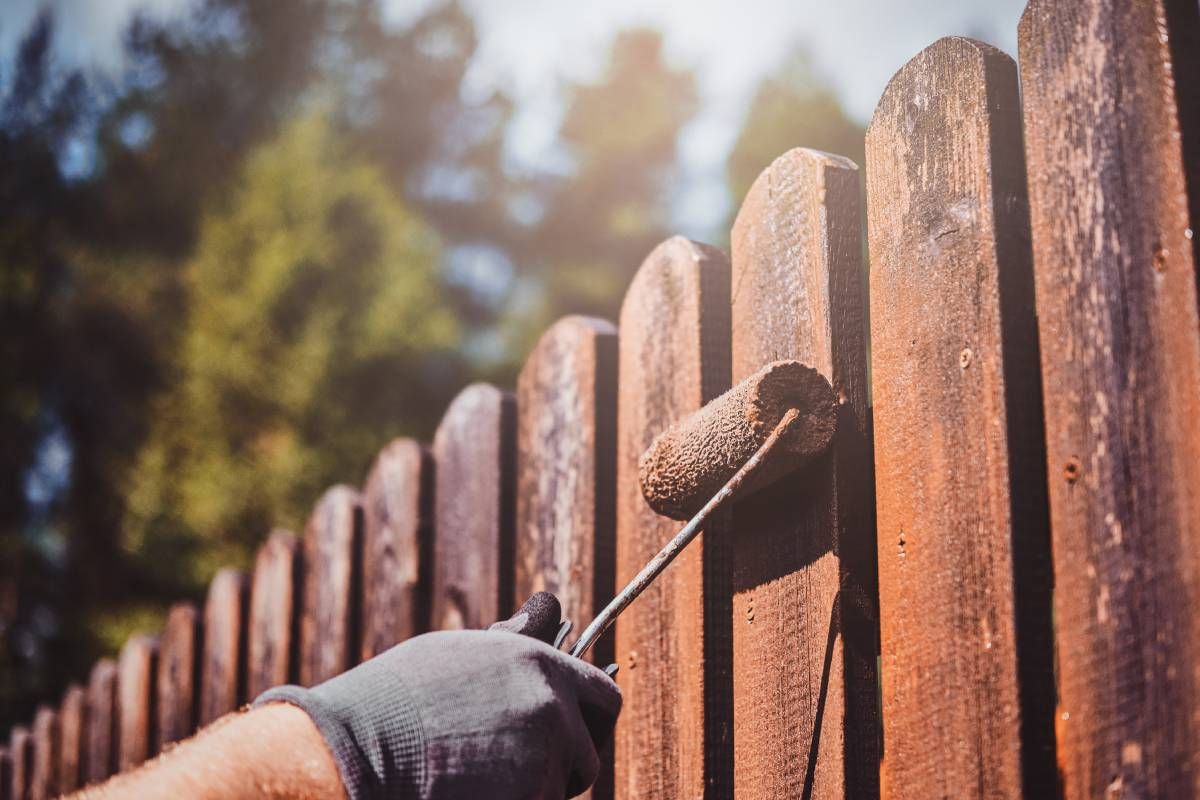Someone with protective gloves painting a fence near Johnson City, Tennessee (TN)