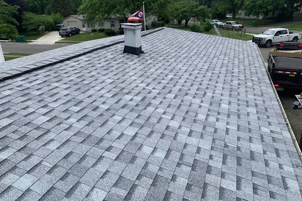 a newly repaired roof with a chimney and a flag on top of it