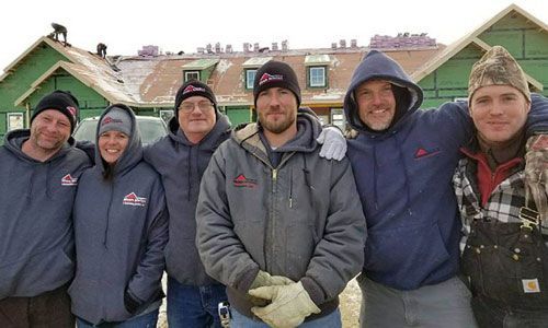 a group of construction workers are posing for a picture in front of a building under construction