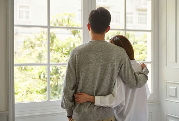 a man and a woman are looking out of a window
