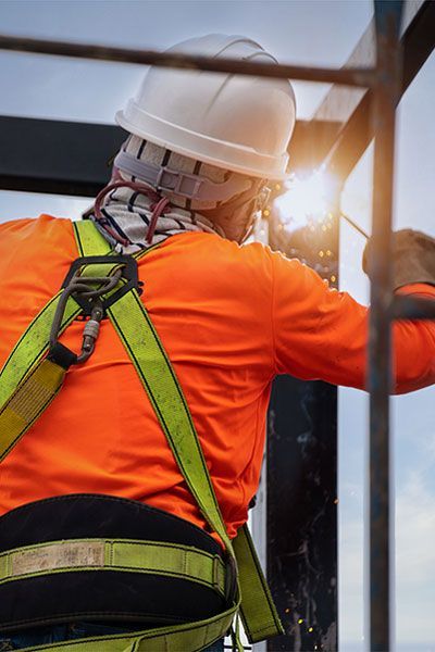 A man wearing a hard hat and safety harness
