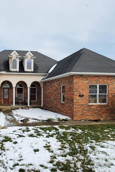 front view of multi-colored brick house with complete roof replacement finished by Allstate Exterior
