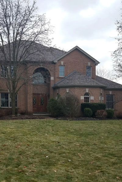A red brick home with a new roof installed by Allstate Exteriors