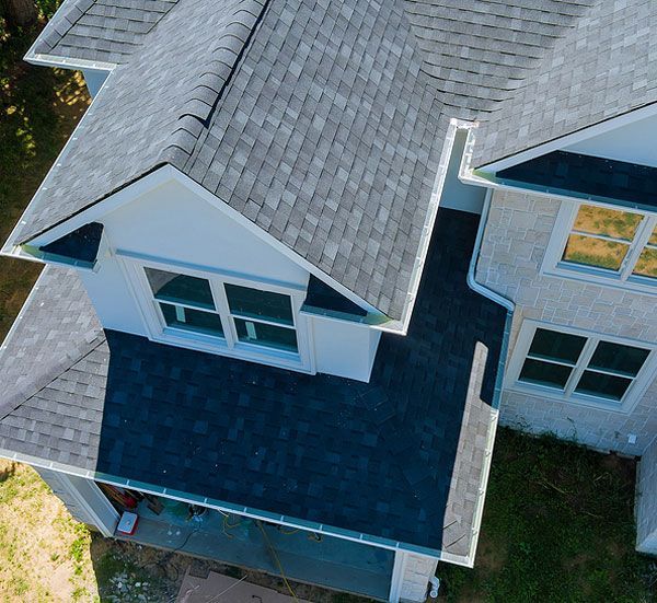 New shingle roof on a brick home with many gables