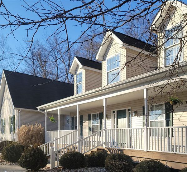 Front view of a tan home with a front porch