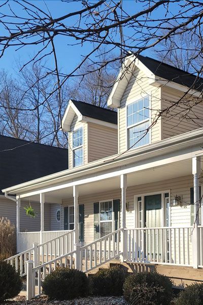 Front view of a tan home with a front porch