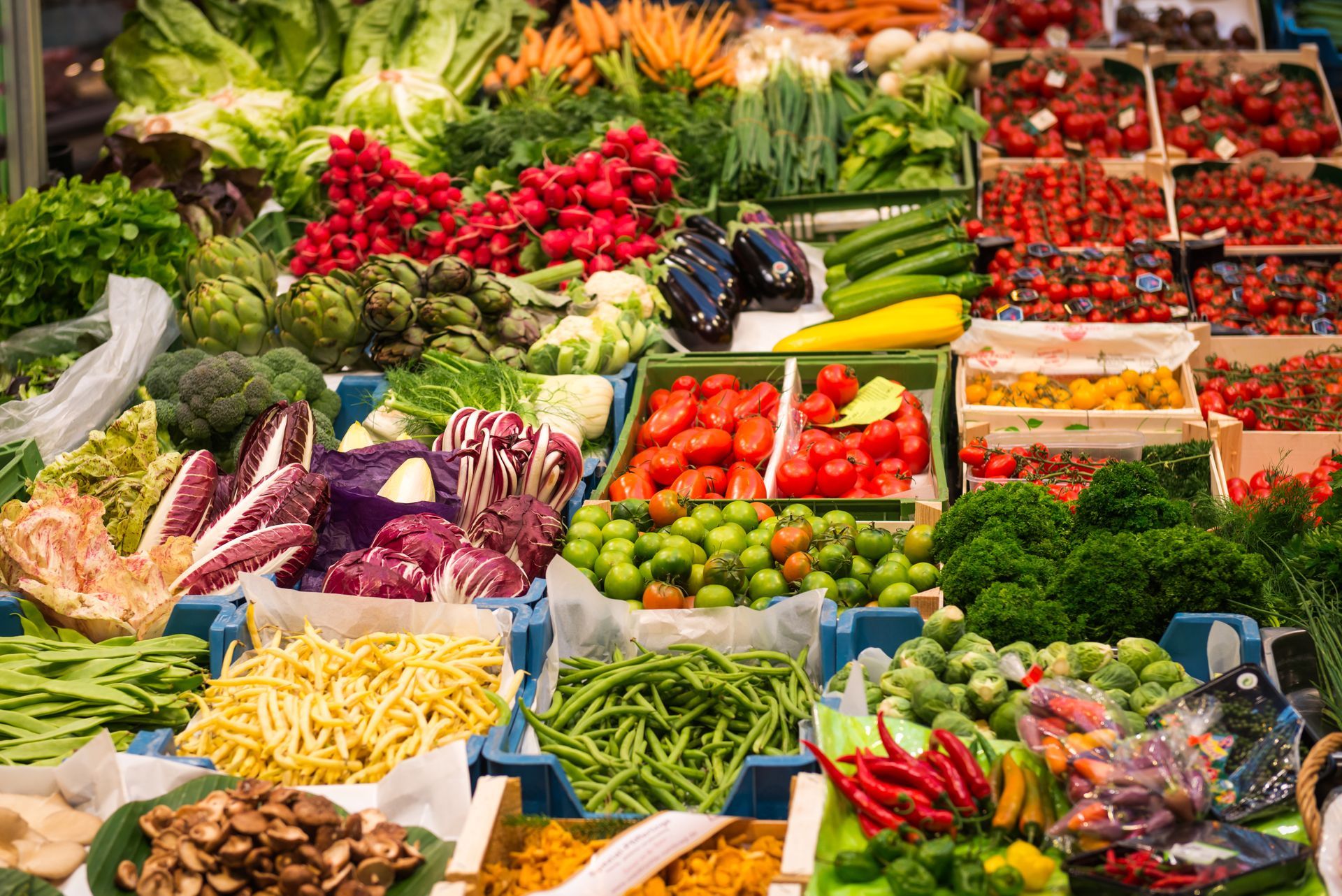 Colorful fresh fruits and vegetables arranged in crates at an outdoor market