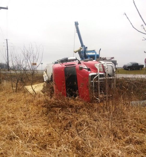 heavy-duty wrecker assists a sideways semi truck