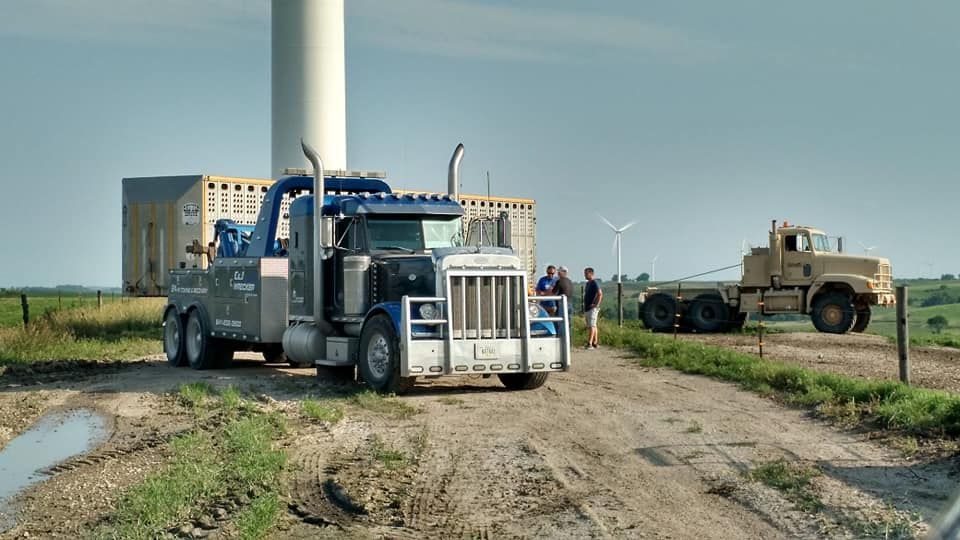 two heavy-duty trucks pose on a dirt road

