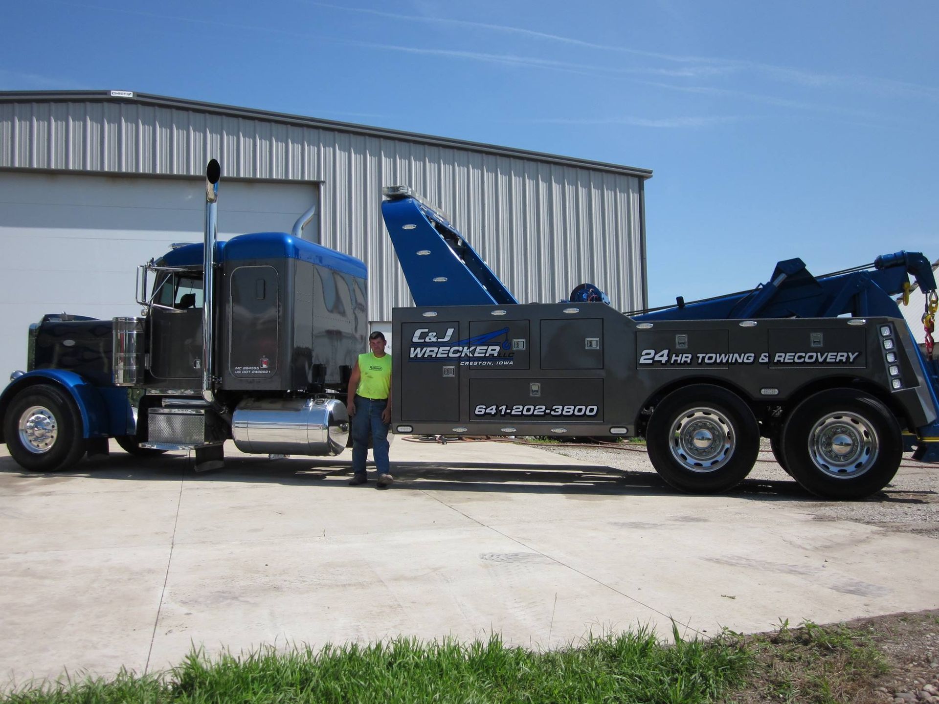 owner posing with heavy-duty wrecker