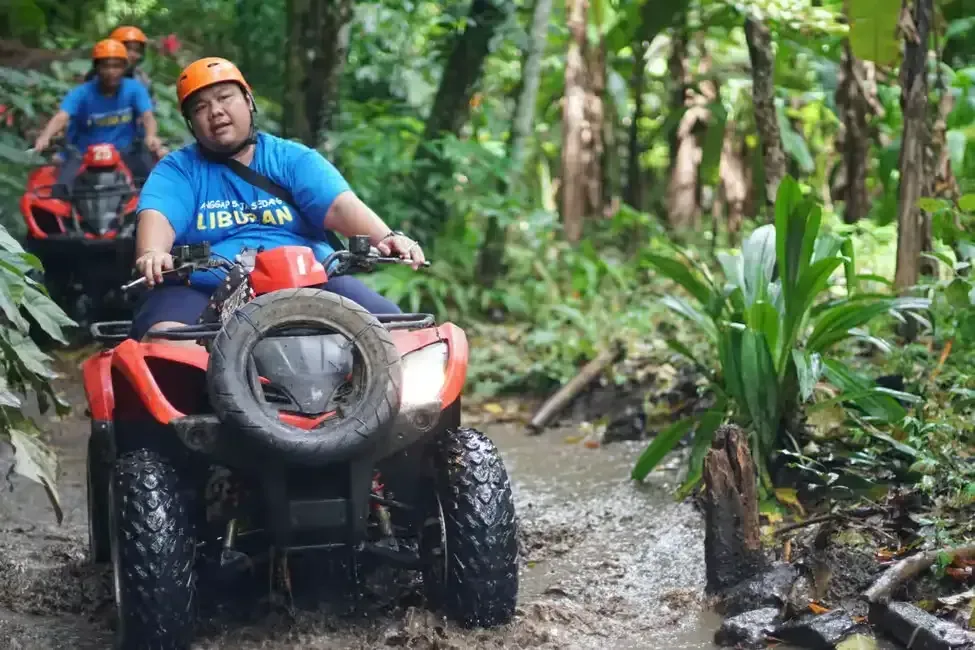 3 man riding atv in muddy road in khlong son