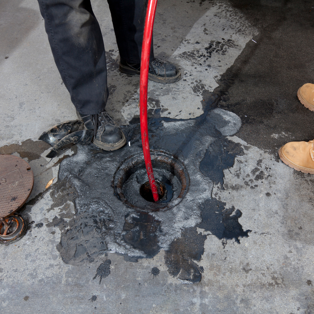 A plumber is working on a pipe with a wrench and a gauge.