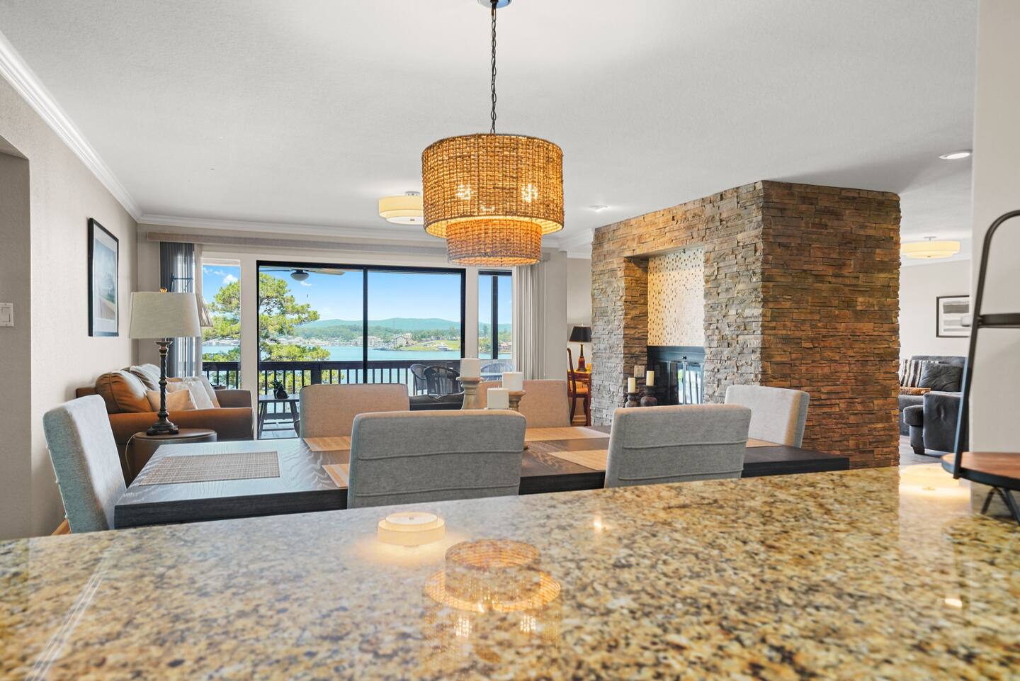 A view of a living room and dining room from a kitchen counter.