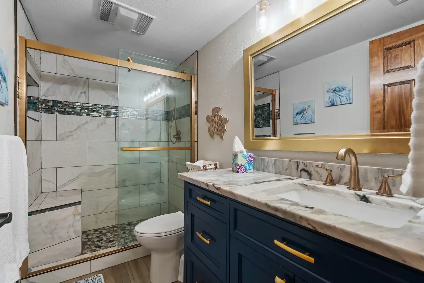A bathroom with a toilet , sink , mirror and shower.
