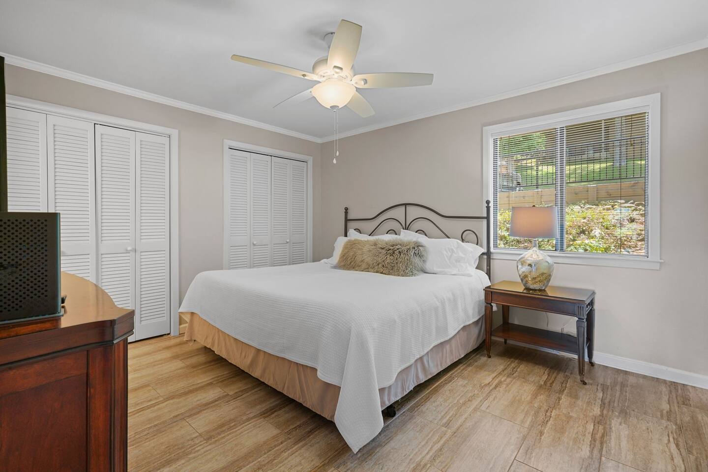 A bedroom with a king size bed and a ceiling fan.
