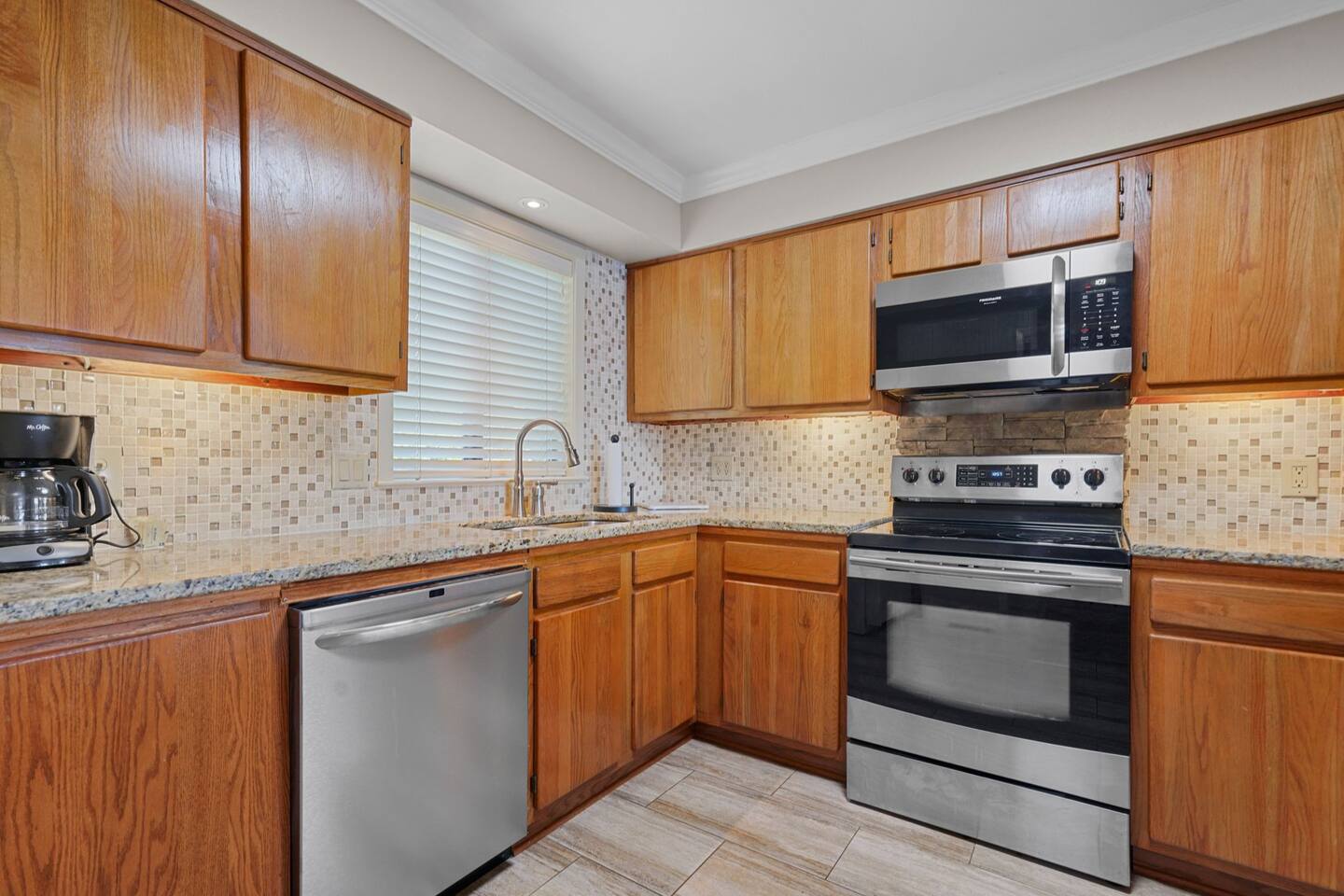 A kitchen with stainless steel appliances and wooden cabinets.