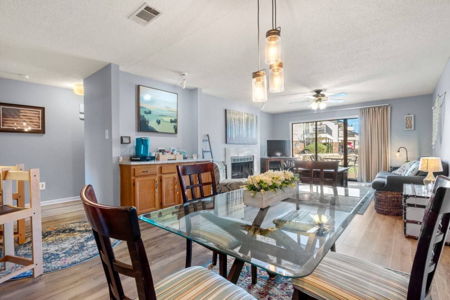 A living room with a glass dining table and chairs.