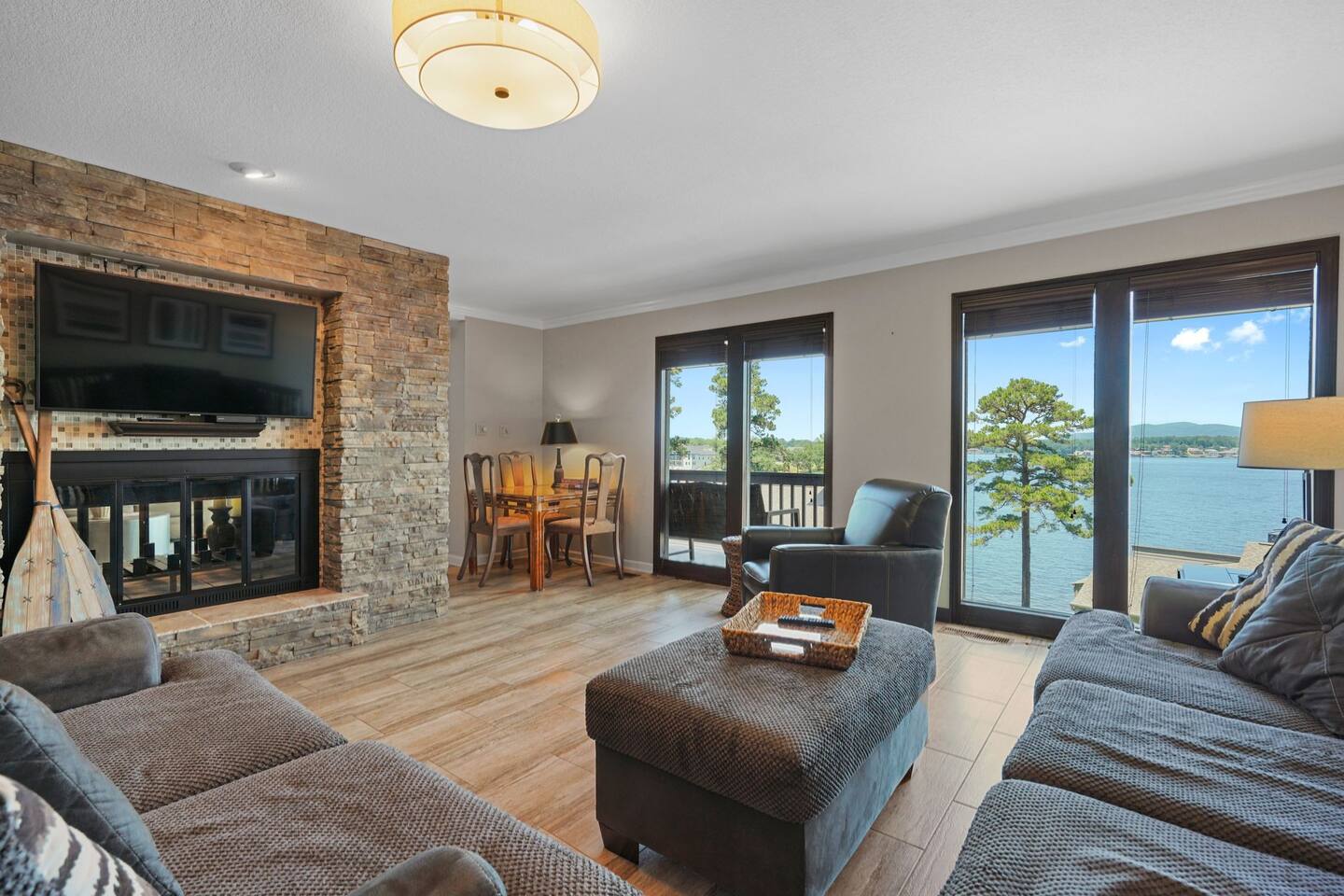 A living room filled with furniture and a fireplace with a view of a lake.