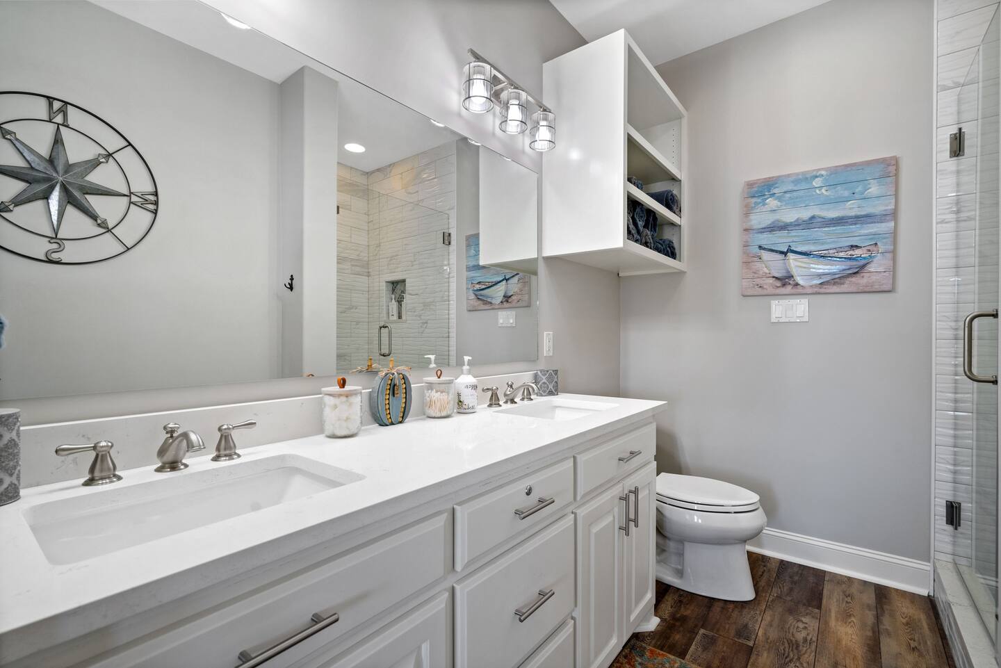 A bathroom with two sinks , a toilet , and a large mirror.