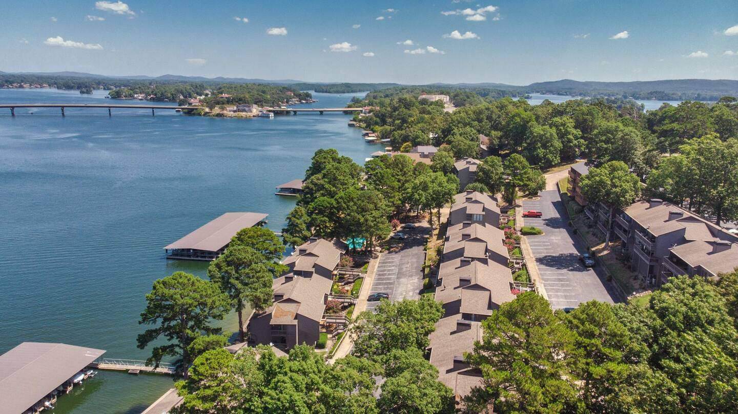 An aerial view of a lake surrounded by trees and houses.