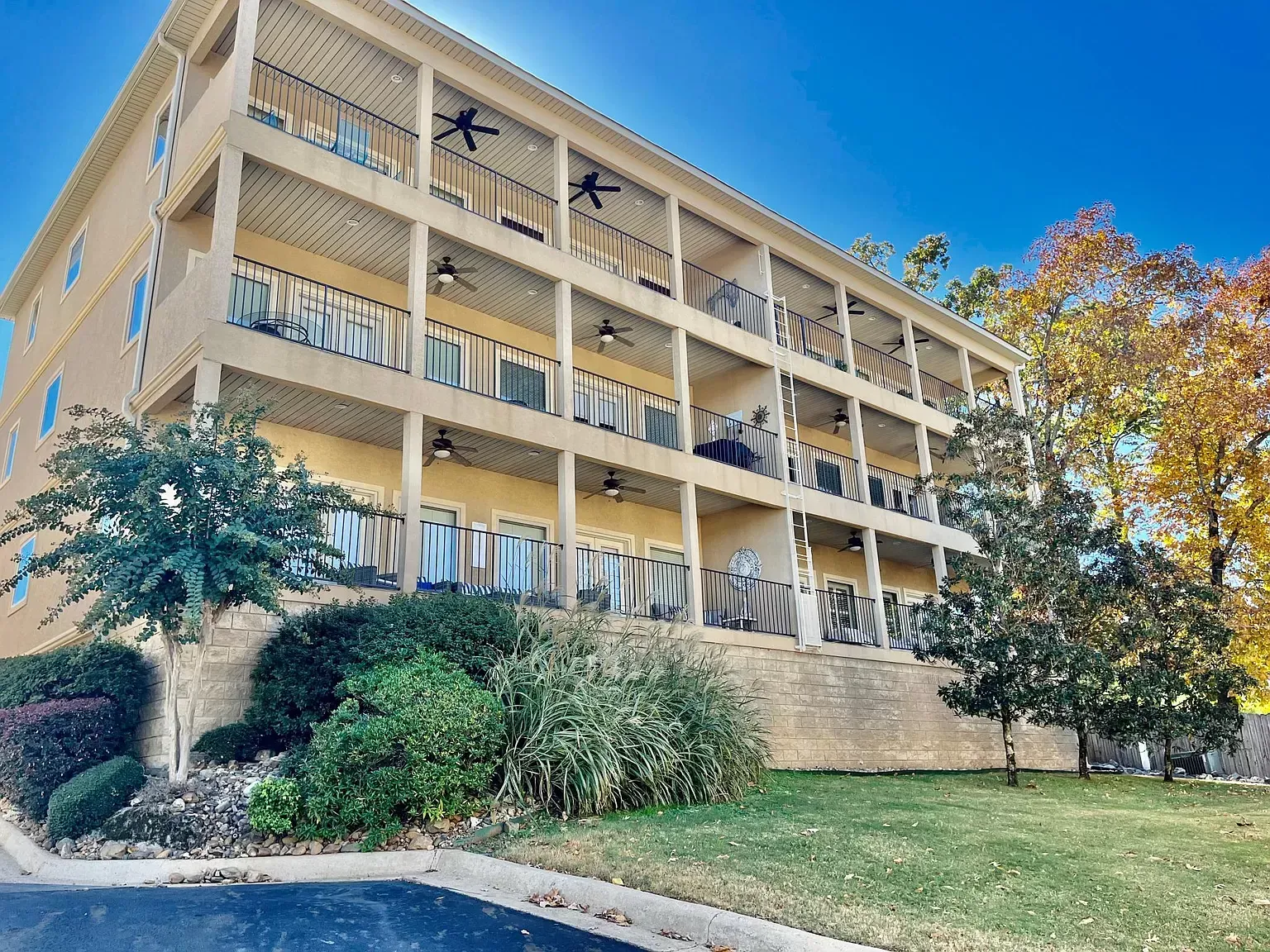 A large apartment building with a lot of balconies and trees in front of it.