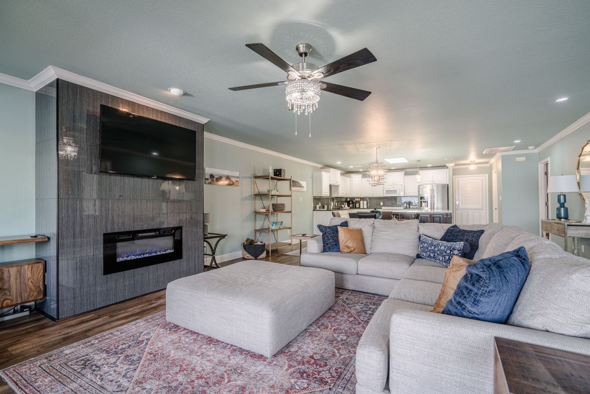 A living room with a couch , ottoman , fireplace and television.