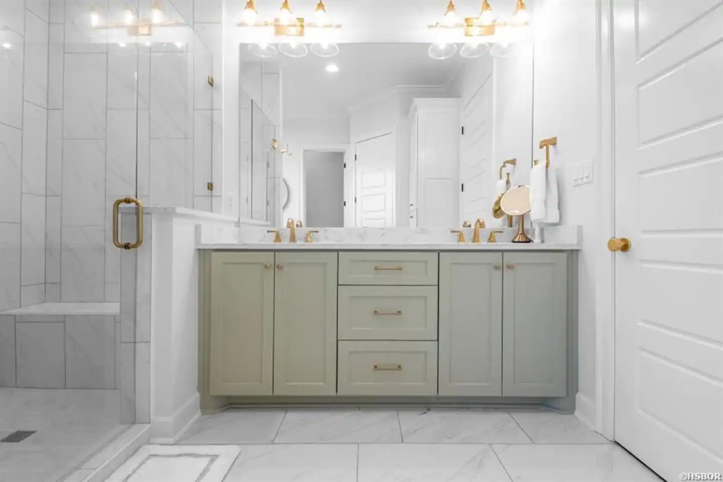 A bathroom with two sinks , a mirror and a walk in shower.