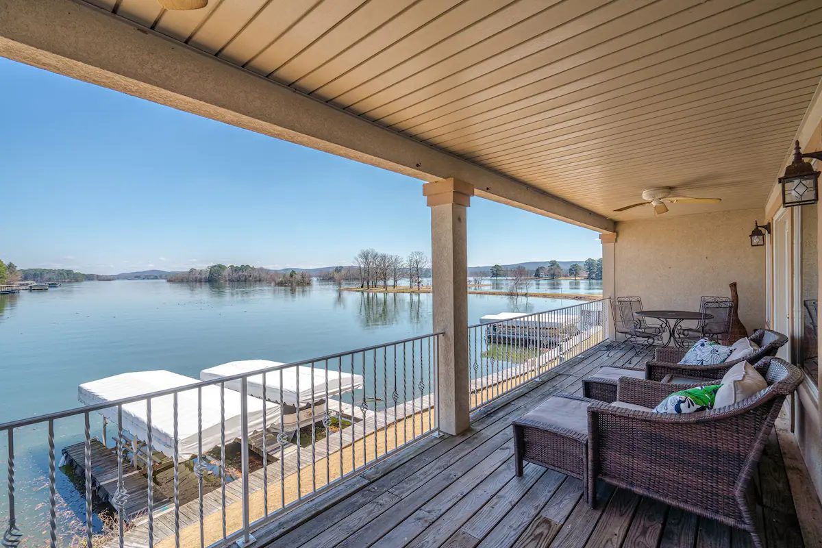 A large porch with a view of a lake.