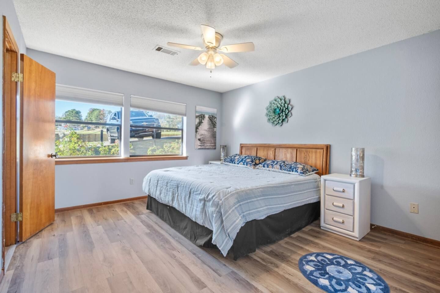 A bedroom with a king size bed and a ceiling fan.