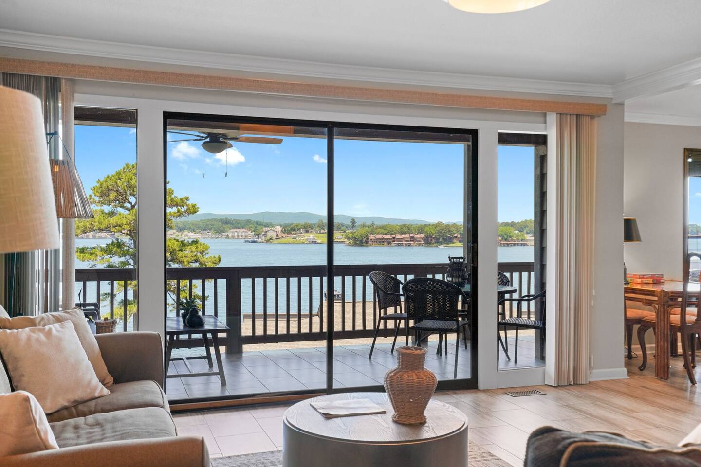 A living room with a view of a lake and a balcony.