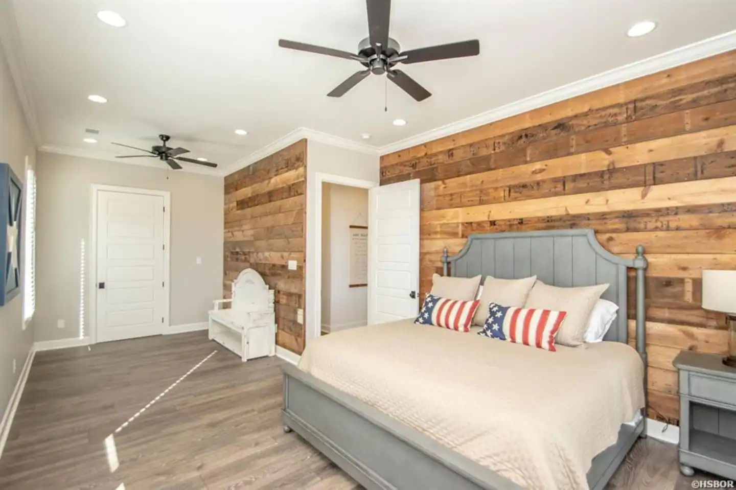 A bedroom with a king size bed and a ceiling fan.