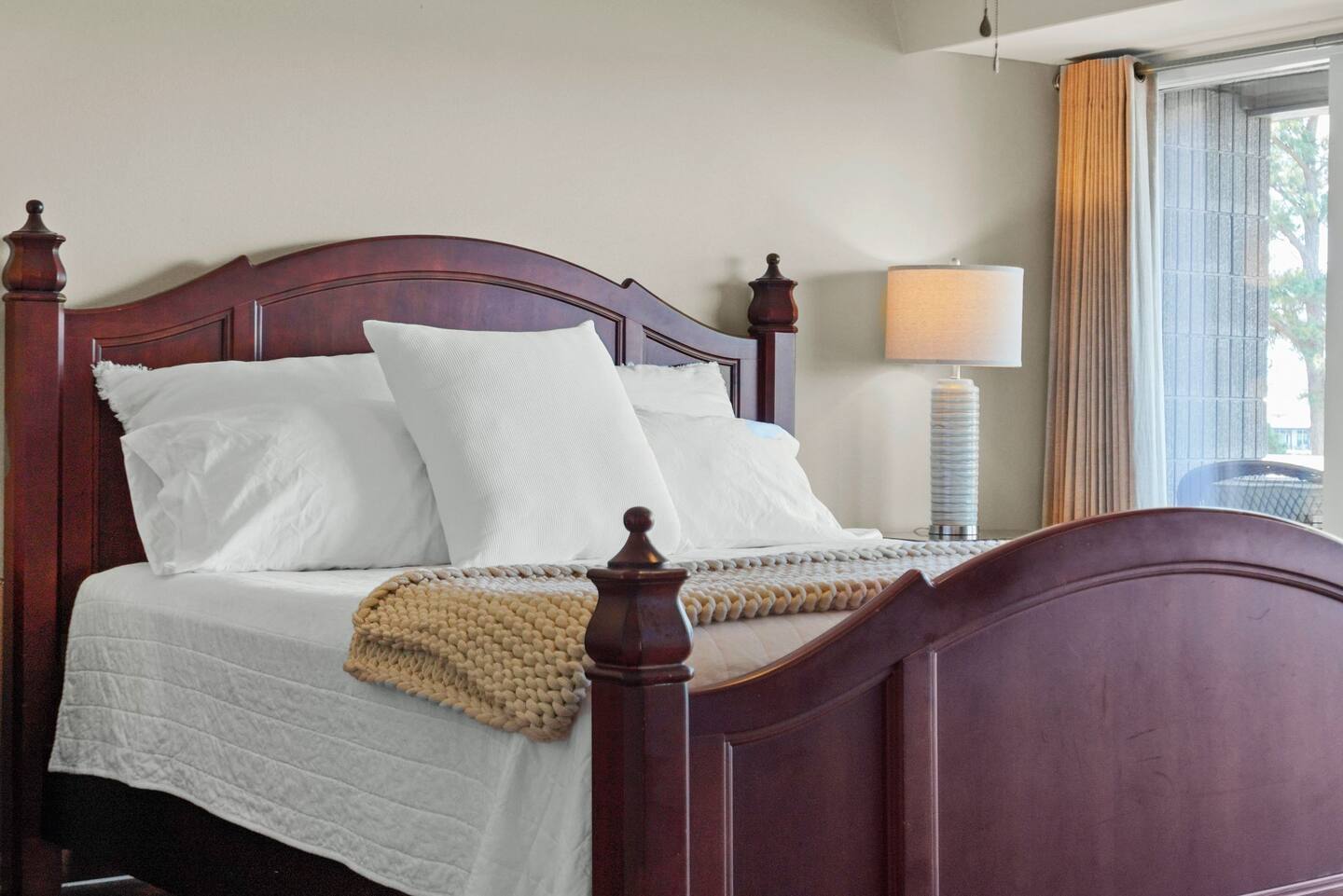 A bed with white sheets and pillows in a bedroom