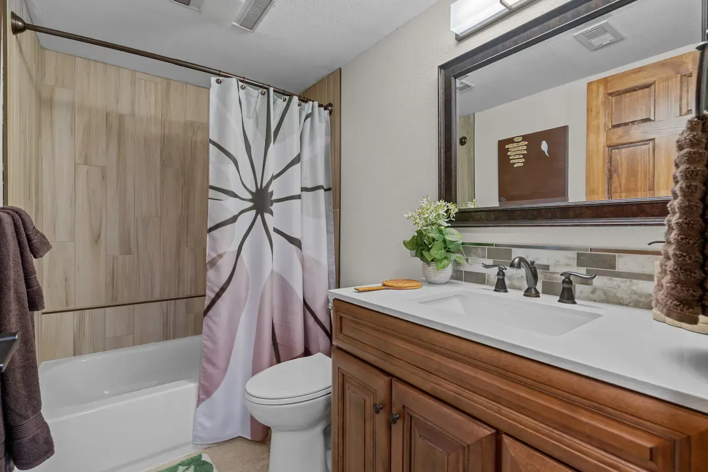 A bathroom with a toilet , sink , and shower curtain.