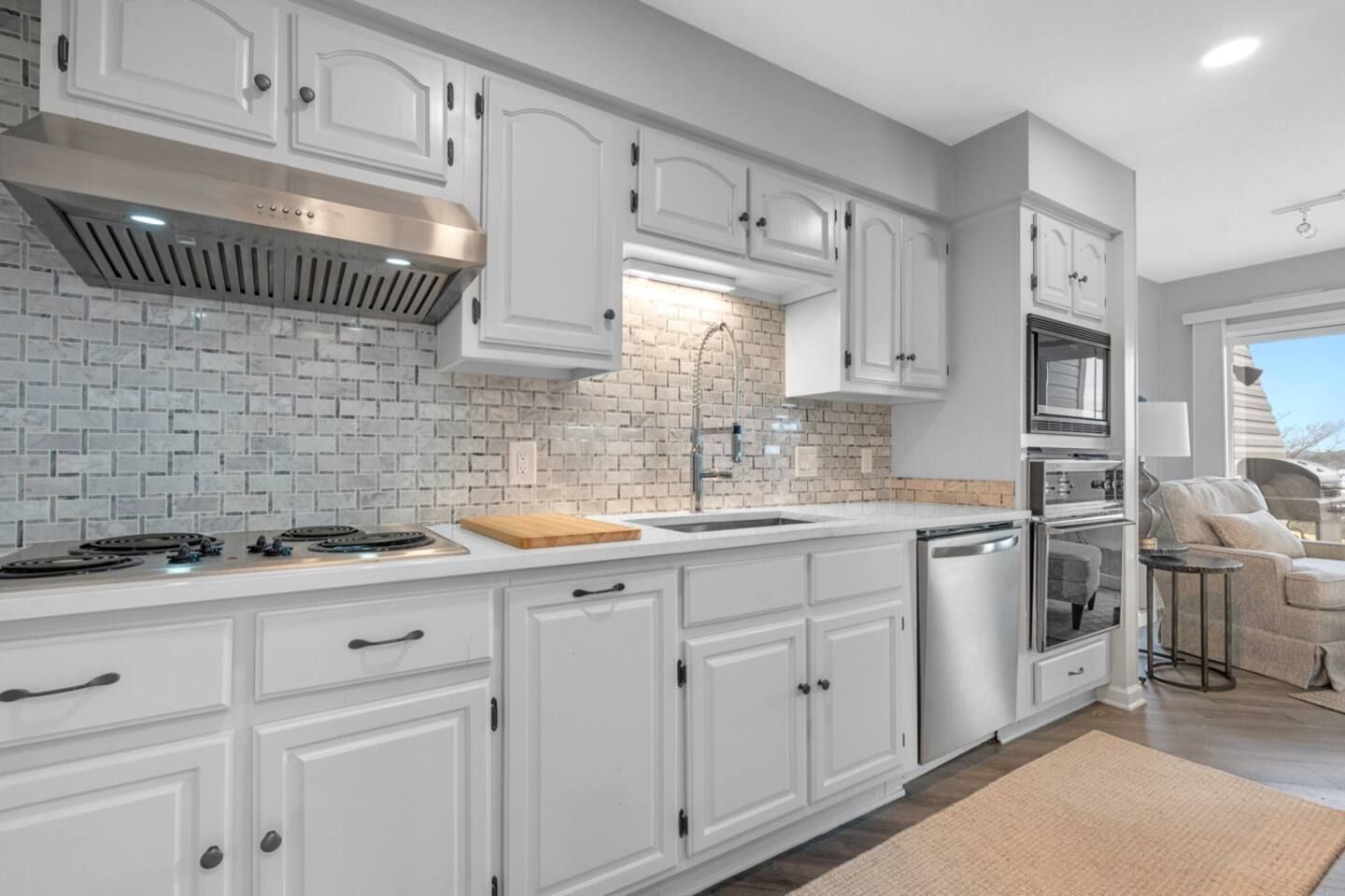 A kitchen with white cabinets and stainless steel appliances.