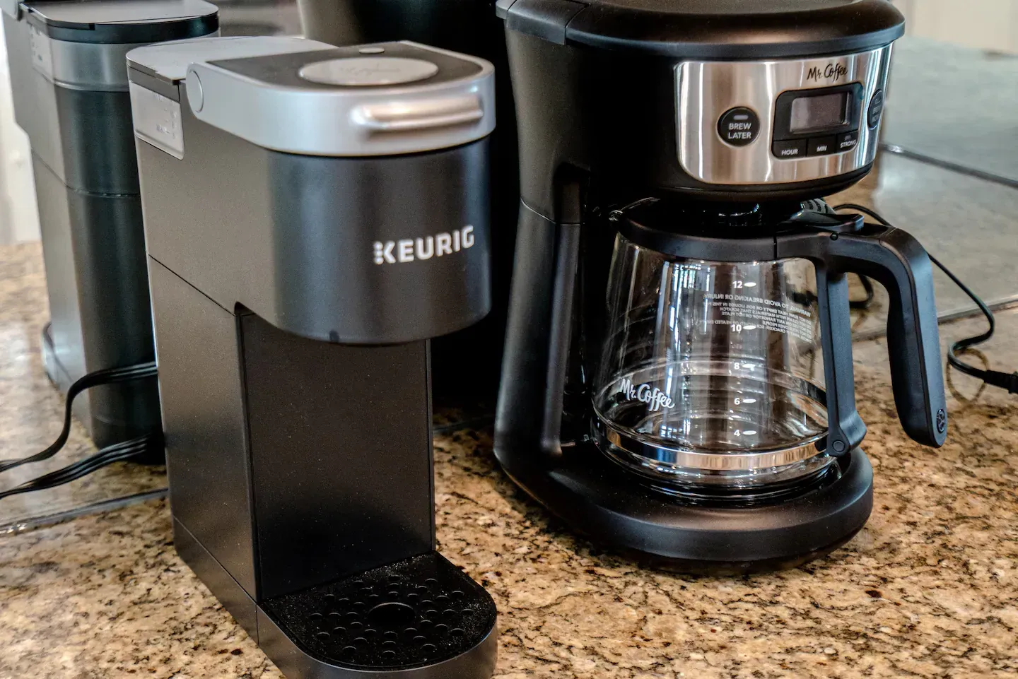 Two keurig coffee makers are sitting on a counter.