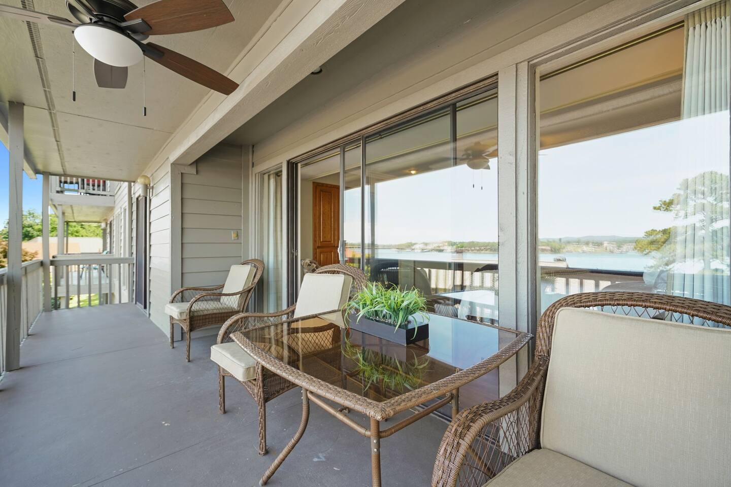 A balcony with a table and chairs and a ceiling fan.
