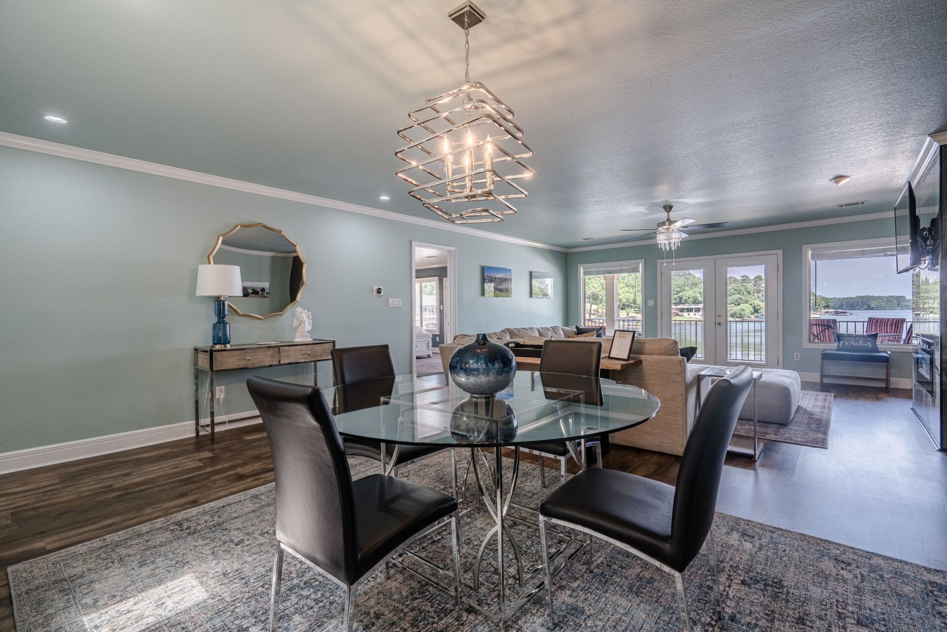 A dining room with a glass table and chairs and a chandelier.