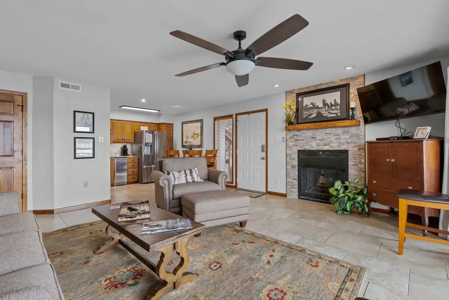A living room with a ceiling fan and a fireplace.