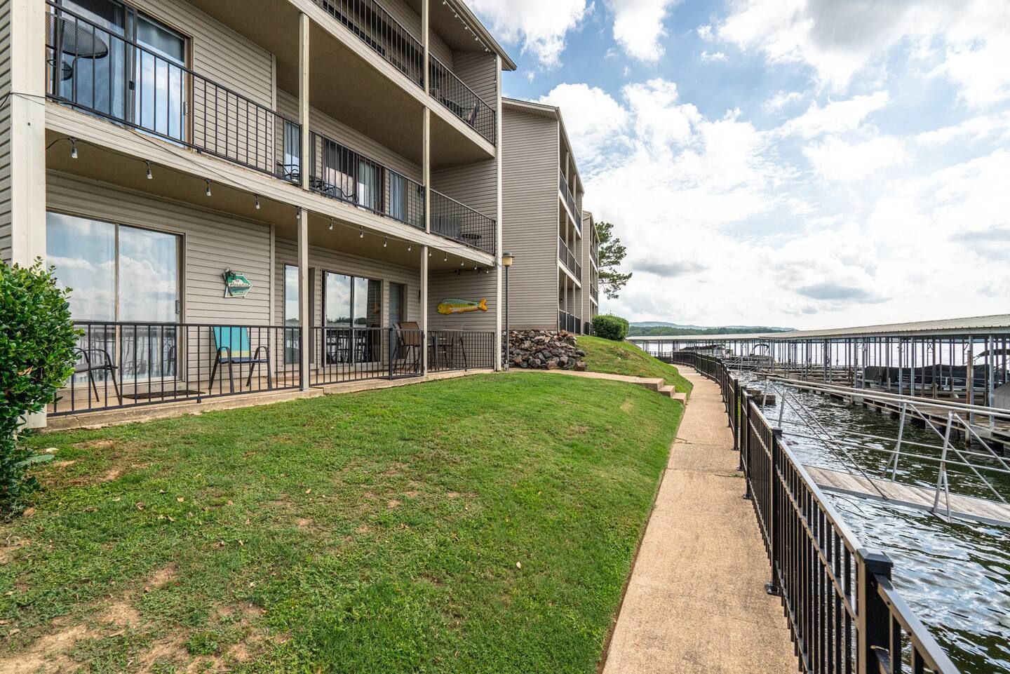 A large apartment building with a walkway leading to the water.
