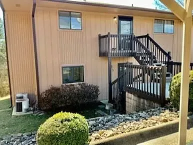A house with a deck and stairs on the side of it.